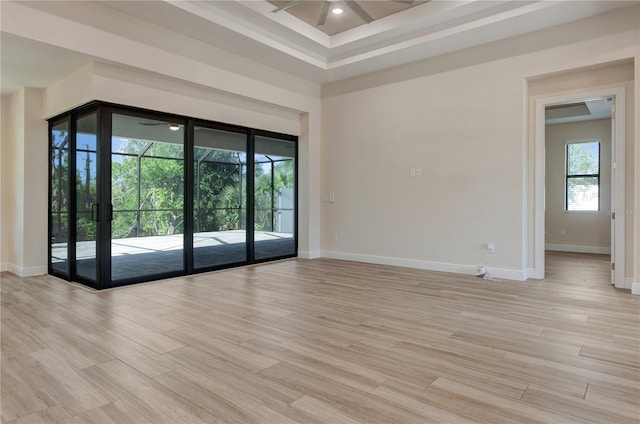 unfurnished room with ceiling fan, light wood finished floors, and baseboards