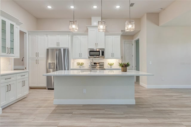 kitchen featuring appliances with stainless steel finishes, a sink, light countertops, decorative backsplash, and recessed lighting