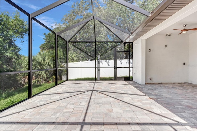 unfurnished sunroom featuring ceiling fan
