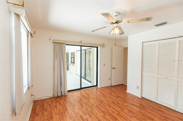 1612 Blue Lake Cir, Punta Gorda, FL 33983 - unfurnished bedroom featuring access to exterior, light wood finished floors, ceiling fan, and a closet