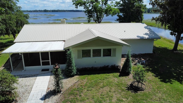 1005 S Sands Paradise Pt, Inverness, FL 34450 - view of front of property with a sunroom, a water view, a front lawn, and metal roof