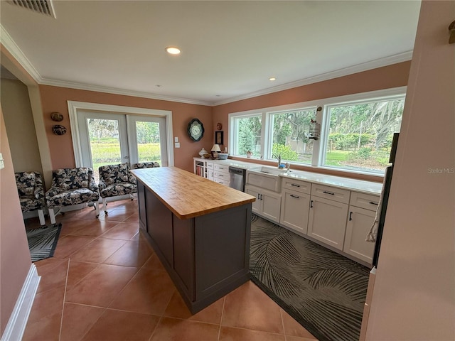 1005 S Sands Paradise Pt, Inverness, FL 34450 - kitchen with butcher block counters, white cabinets, a sink, dishwasher, and a center island