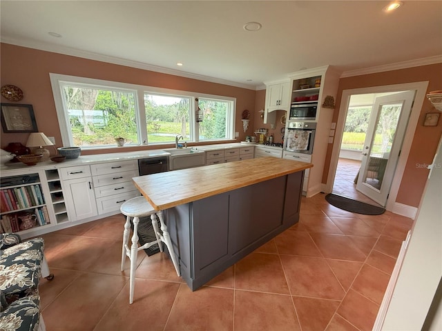 1005 S Sands Paradise Pt, Inverness, FL 34450 - kitchen featuring butcher block counters, open shelves, stainless steel appliances, light tile patterned flooring, and ornamental molding