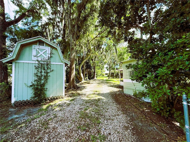 1005 S Sands Paradise Pt, Inverness, FL 34450 - view of yard featuring a storage shed, an outbuilding, and gravel driveway
