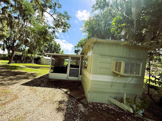 1005 S Sands Paradise Pt, Inverness, FL 34450 - view of home's exterior featuring a storage shed, an outdoor structure, and a sunroom