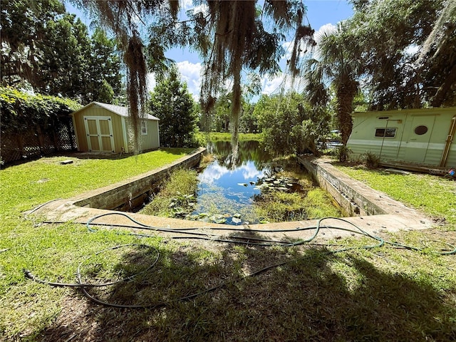 1005 S Sands Paradise Pt, Inverness, FL 34450 - view of grassy yard with a shed, a water view, and an outbuilding