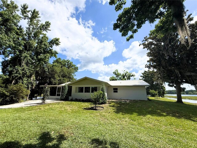 1005 S Sands Paradise Pt, Inverness, FL 34450 - view of front of house with a front lawn, concrete driveway, and a water view