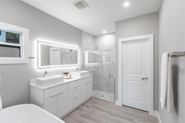 19160 Ruskin Ave, Port Charlotte, FL 33954 - bathroom with a marble finish shower, a soaking tub, double vanity, wood finished floors, and recessed lighting