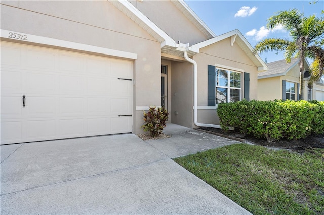 25312 E Lenox Cir, Punta Gorda, FL 33950 - view of front of home featuring stucco siding, concrete driveway, and an attached garage