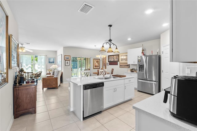 25312 E Lenox Cir, Punta Gorda, FL 33950 - kitchen with appliances with stainless steel finishes, a sink, white cabinetry, light countertops, and a kitchen island with sink