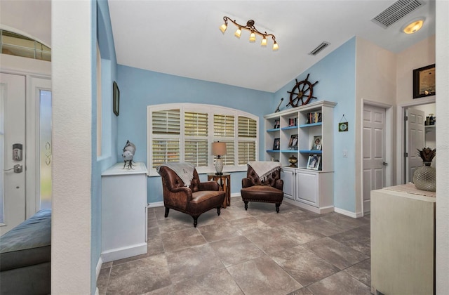 living area with lofted ceiling and baseboards