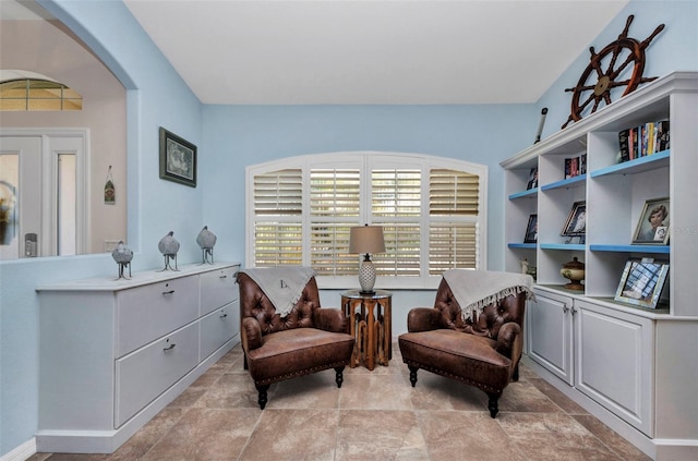 living area featuring arched walkways and light stone finish floors