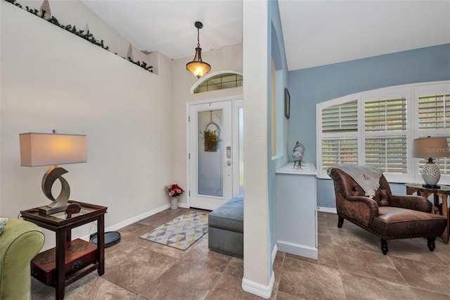 entrance foyer featuring baseboards and a towering ceiling
