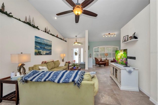 living area featuring baseboards, a ceiling fan, vaulted ceiling, and light tile patterned flooring
