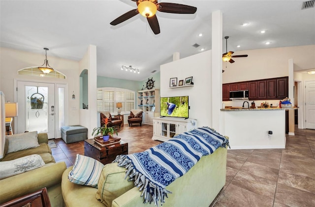 tiled living room featuring ceiling fan and vaulted ceiling
