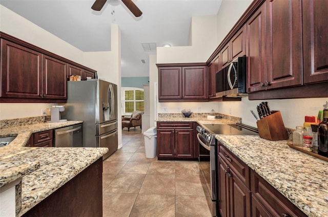 kitchen with stainless steel appliances, ceiling fan, light stone countertops, and light tile patterned flooring
