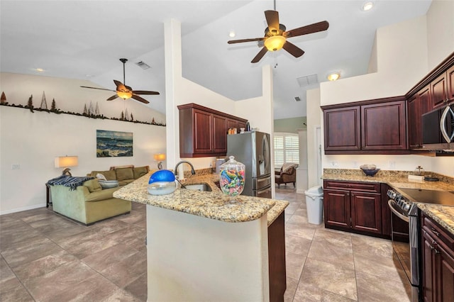 kitchen featuring a ceiling fan, appliances with stainless steel finishes, a sink, a peninsula, and open floor plan