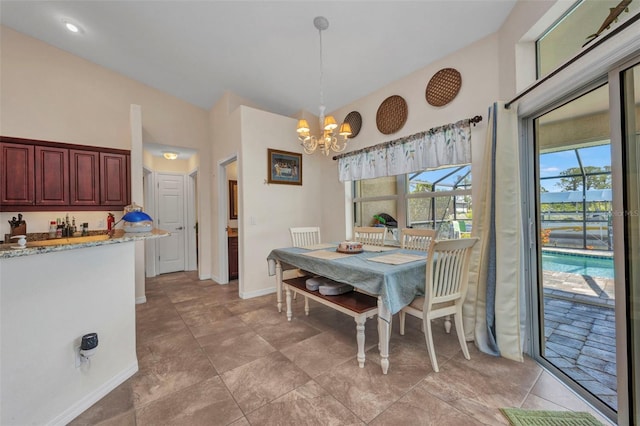 dining room featuring a chandelier, baseboards, and lofted ceiling