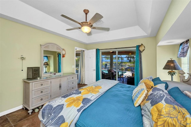 bedroom with a raised ceiling, access to outside, baseboards, and a ceiling fan