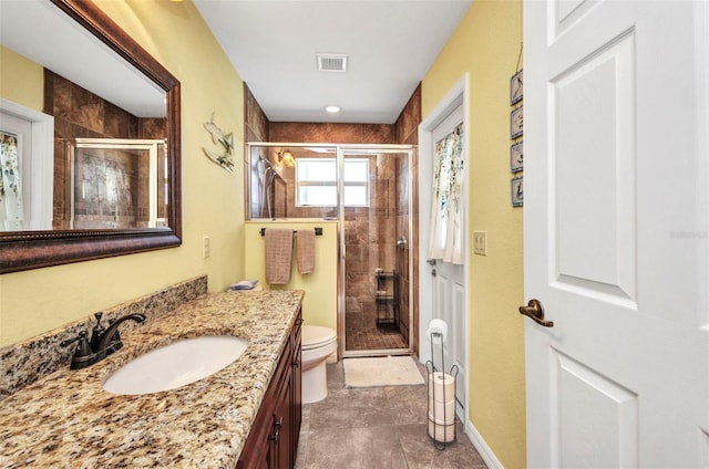 full bathroom with a stall shower, vanity, toilet, and tile patterned floors