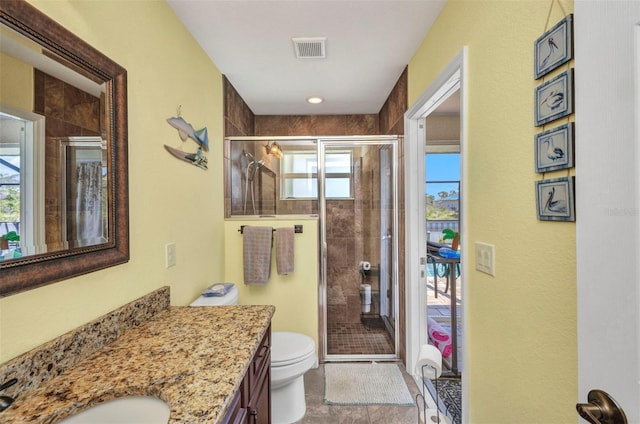 full bathroom with vanity, a shower stall, and toilet
