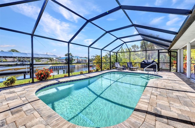 outdoor pool featuring a patio, a water view, a lanai, a boat dock, and boat lift