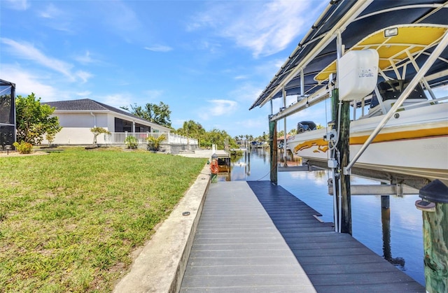 dock area featuring boat lift, a yard, and a water view