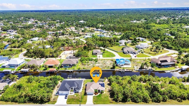 aerial view of residential area featuring a large body of water and a heavily wooded area