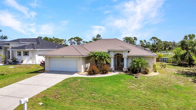 ranch-style house featuring an attached garage, driveway, stucco siding, a front lawn, and metal roof