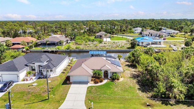 aerial perspective of suburban area with a nearby body of water and a heavily wooded area