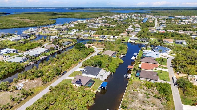 aerial view of property and surrounding area with a large body of water and nearby suburban area