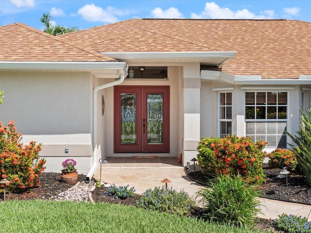 85 Long Meadow Ct, Rotonda West, FL 33947 - property entrance with french doors, roof with shingles, and stucco siding