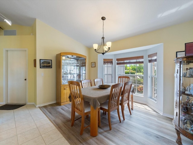 85 Long Meadow Ct, Rotonda West, FL 33947 - dining room featuring a chandelier, light wood-style floors, vaulted ceiling, and baseboards