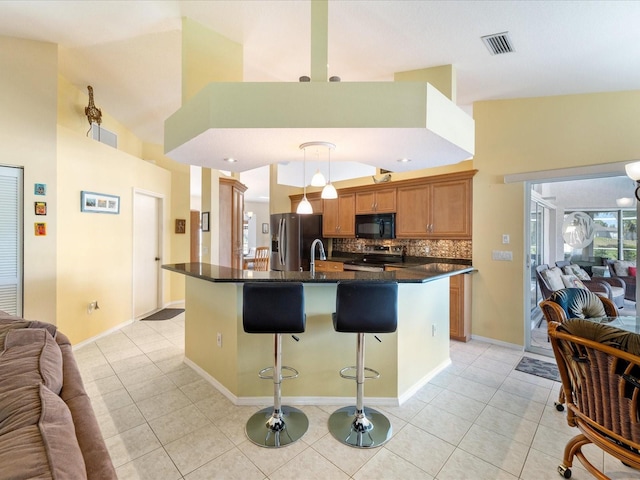 85 Long Meadow Ct, Rotonda West, FL 33947 - kitchen featuring appliances with stainless steel finishes, open floor plan, a kitchen breakfast bar, light tile patterned flooring, and high vaulted ceiling