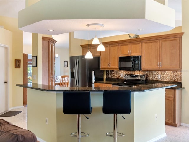 85 Long Meadow Ct, Rotonda West, FL 33947 - kitchen featuring stainless steel appliances, light tile patterned floors, a kitchen bar, and backsplash