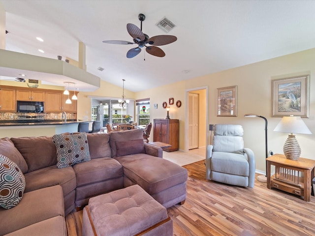 85 Long Meadow Ct, Rotonda West, FL 33947 - living area with lofted ceiling, a ceiling fan, light wood-type flooring, and a chandelier