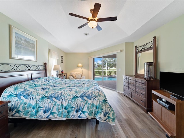 85 Long Meadow Ct, Rotonda West, FL 33947 - bedroom with access to outside, wood finished floors, a ceiling fan, lofted ceiling, and a tray ceiling