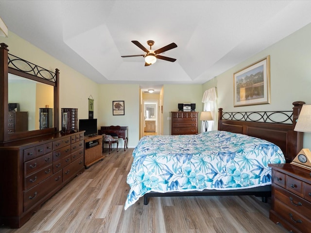 85 Long Meadow Ct, Rotonda West, FL 33947 - bedroom with a tray ceiling, light wood-type flooring, ensuite bath, and a ceiling fan
