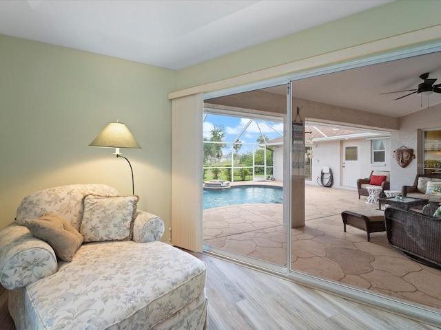 85 Long Meadow Ct, Rotonda West, FL 33947 - sitting room with a sunroom, a ceiling fan, wood finished floors, and a swimming pool
