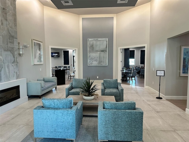 14271 Heritage Landing Blvd Unit 1516, Punta Gorda, FL 33955 - living room featuring a towering ceiling, light tile patterned floors, a fireplace, and baseboards