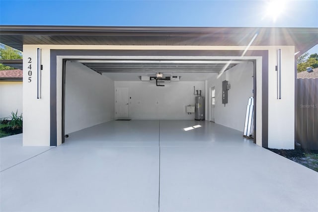 garage with electric water heater, driveway, electric panel, and fence