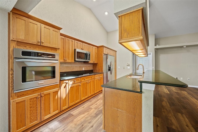 501 Fairmont Ter, Port Charlotte, FL 33954 - kitchen featuring stainless steel appliances, a sink, light wood finished floors, decorative backsplash, and lofted ceiling