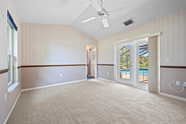501 Fairmont Ter, Port Charlotte, FL 33954 - carpeted spare room featuring lofted ceiling, healthy amount of natural light, a ceiling fan, and wallpapered walls