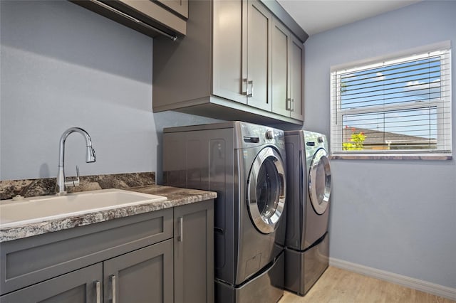 501 Fairmont Ter, Port Charlotte, FL 33954 - washroom featuring washer and dryer, cabinet space, light wood-type flooring, and baseboards