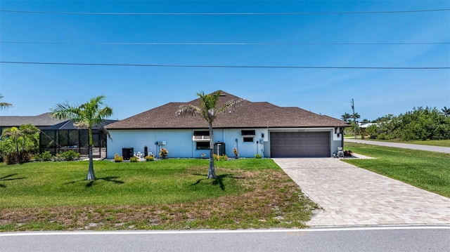 ranch-style house with driveway, an attached garage, a front lawn, and stucco siding
