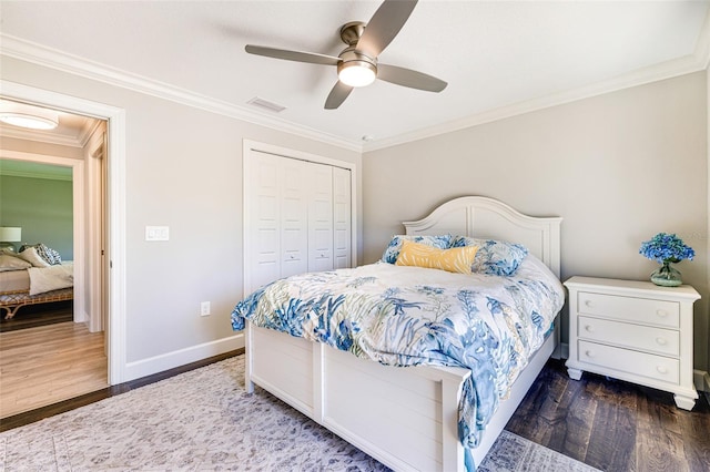 bedroom featuring wood finished floors, crown molding, baseboards, a closet, and a ceiling fan