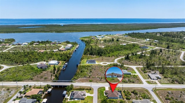 aerial view of property and surrounding area with a large body of water and nearby suburban area