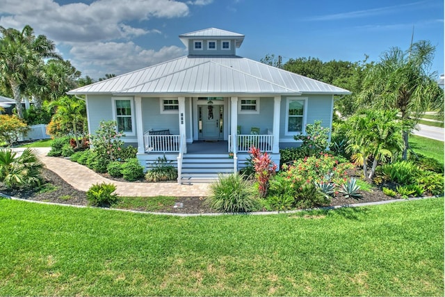 329 W Grace St, Punta Gorda, FL 33950 - bungalow with a porch, a front lawn, and metal roof