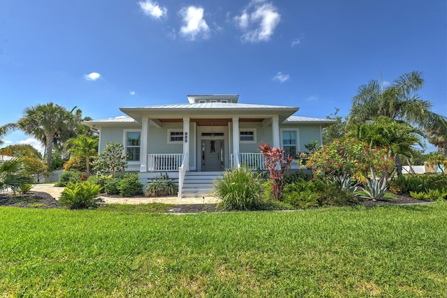 329 W Grace St, Punta Gorda, FL 33950 - bungalow-style house with a porch, a front lawn, and a standing seam roof