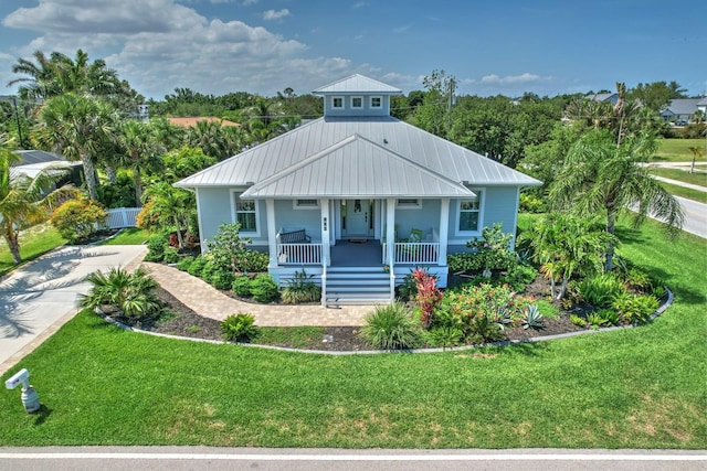 329 W Grace St, Punta Gorda, FL 33950 - view of front of home featuring a porch, a front yard, and metal roof